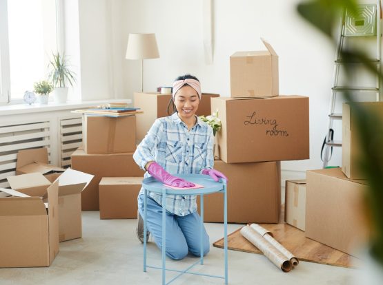 happy-asian-woman-cleaning-new-house-after-moving-JKHF2VY